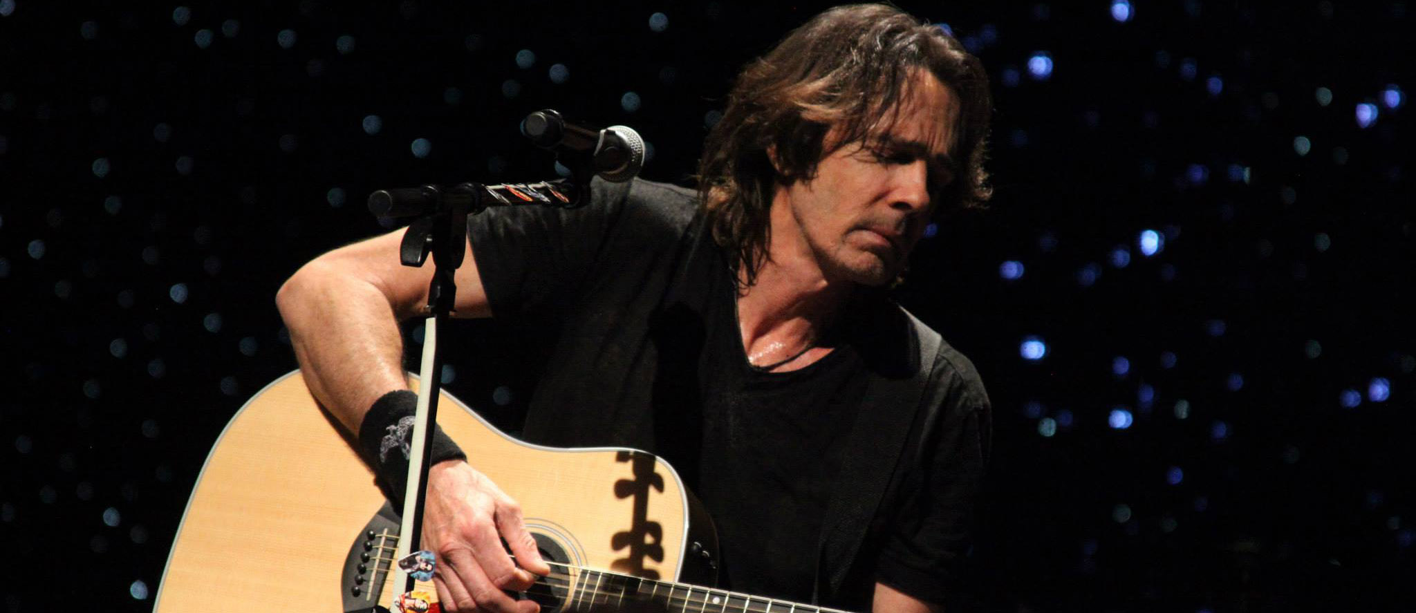 Rick Springfield on stage with acoustic guitar